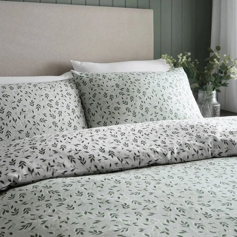 Floral patterned bedding set on a bed with a neutral headboard.