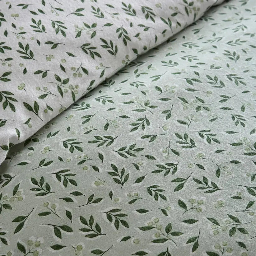 Fabric with green leaf pattern on a light gray background